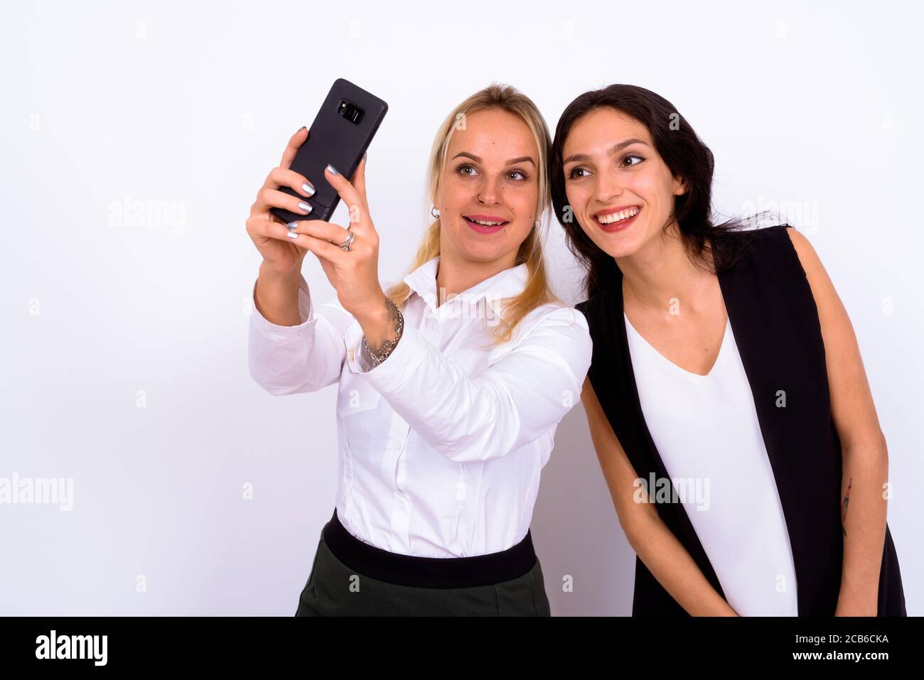 Ritratto di due giovani felici belle donne d'affari che prendono selfie insieme Foto Stock