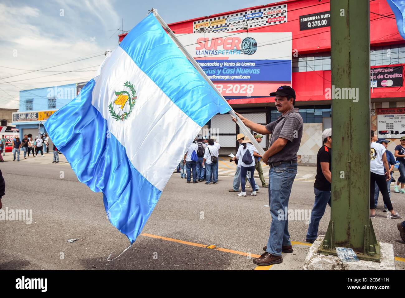 Città del Guatemala / Guatemala - 27 agosto 2015: Uomo guatemalteco che sventolava una grande bandiera guatemalteca durante la protesta anti-governativa per le strade Foto Stock