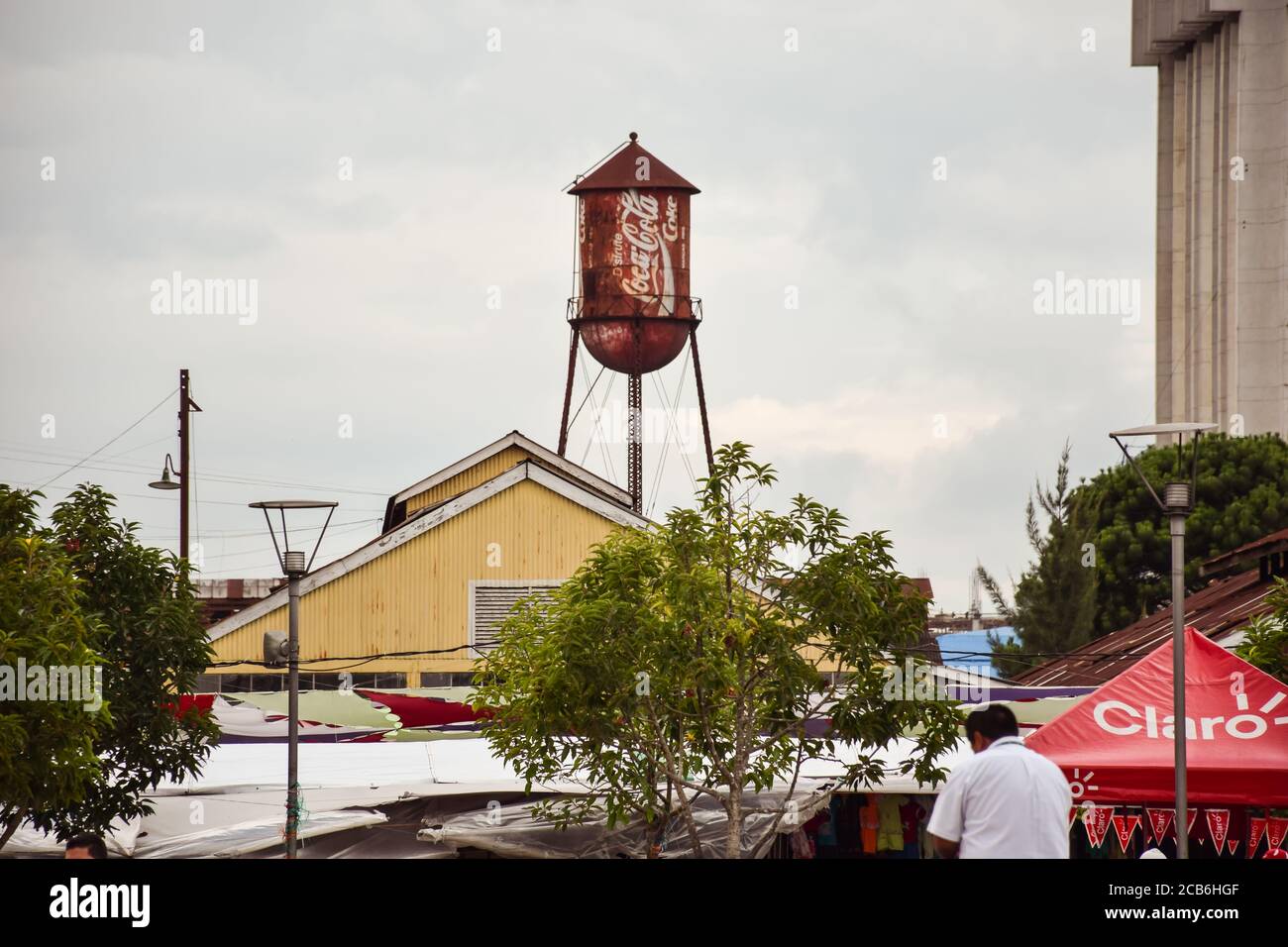 Città del Guatemala / Guatemala - 15 settembre 2016: Vecchio serbatoio di acqua arrugginita con il logo Coca Cola sollevato sopra la capitale del Guatemala Foto Stock