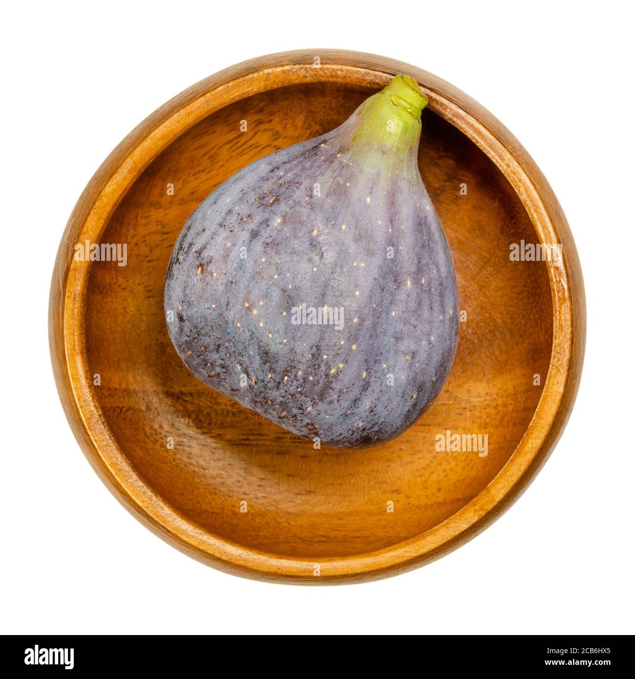 Fico fresco, maturo e intero, in una ciotola di legno. Frutta commestibile e cruda con pelle viola. Fichi comuni possono essere mangiati freschi, asciugati o come marmellata. Ficus carica. Foto Stock
