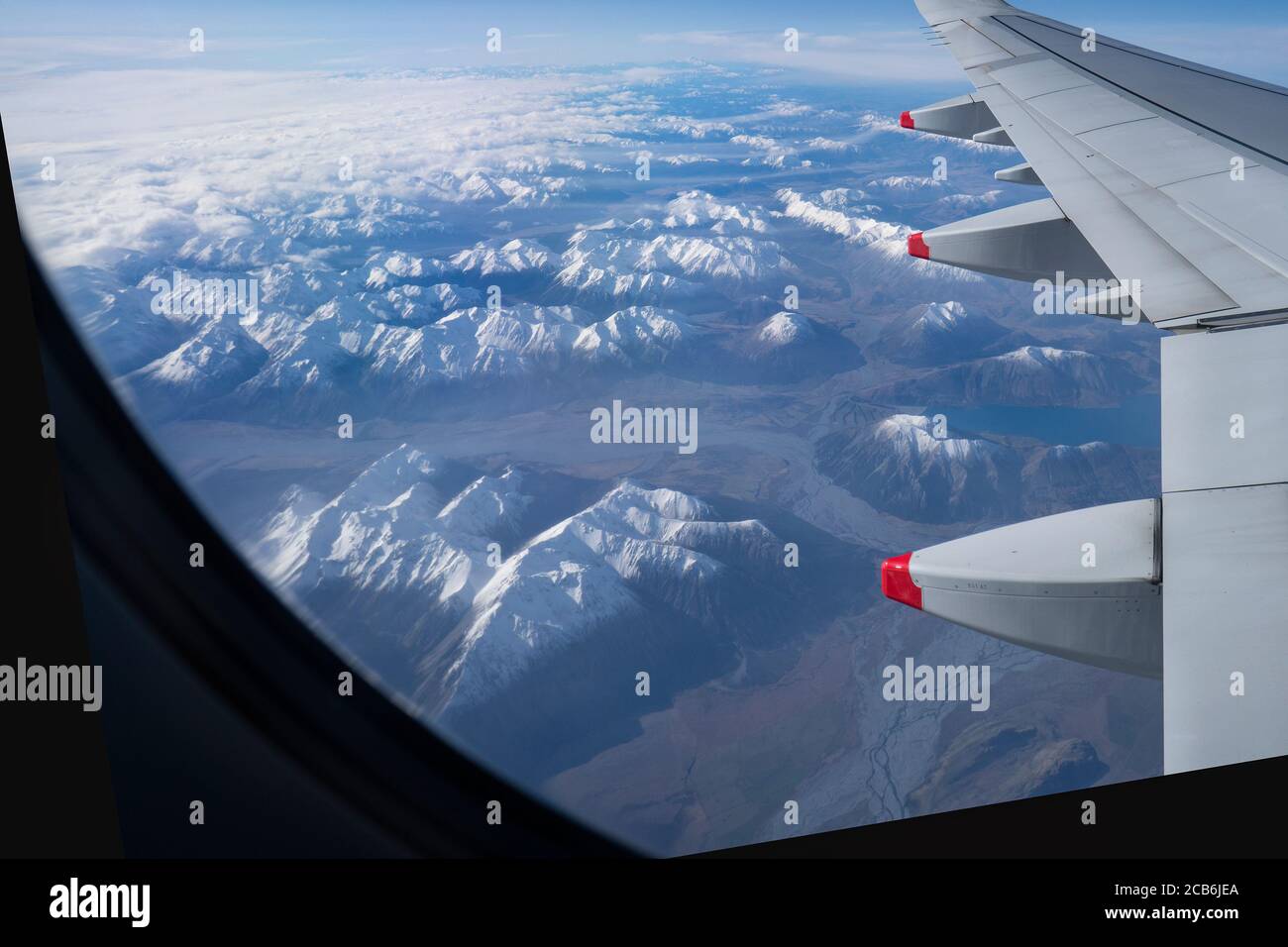 Vista aerea delle montagne e dei fiumi innevati dell'Isola del Sud in inverno da una finestra dell'aeroplano. Immagine tratta dal volo che si avvicina a Queenstown. Foto Stock