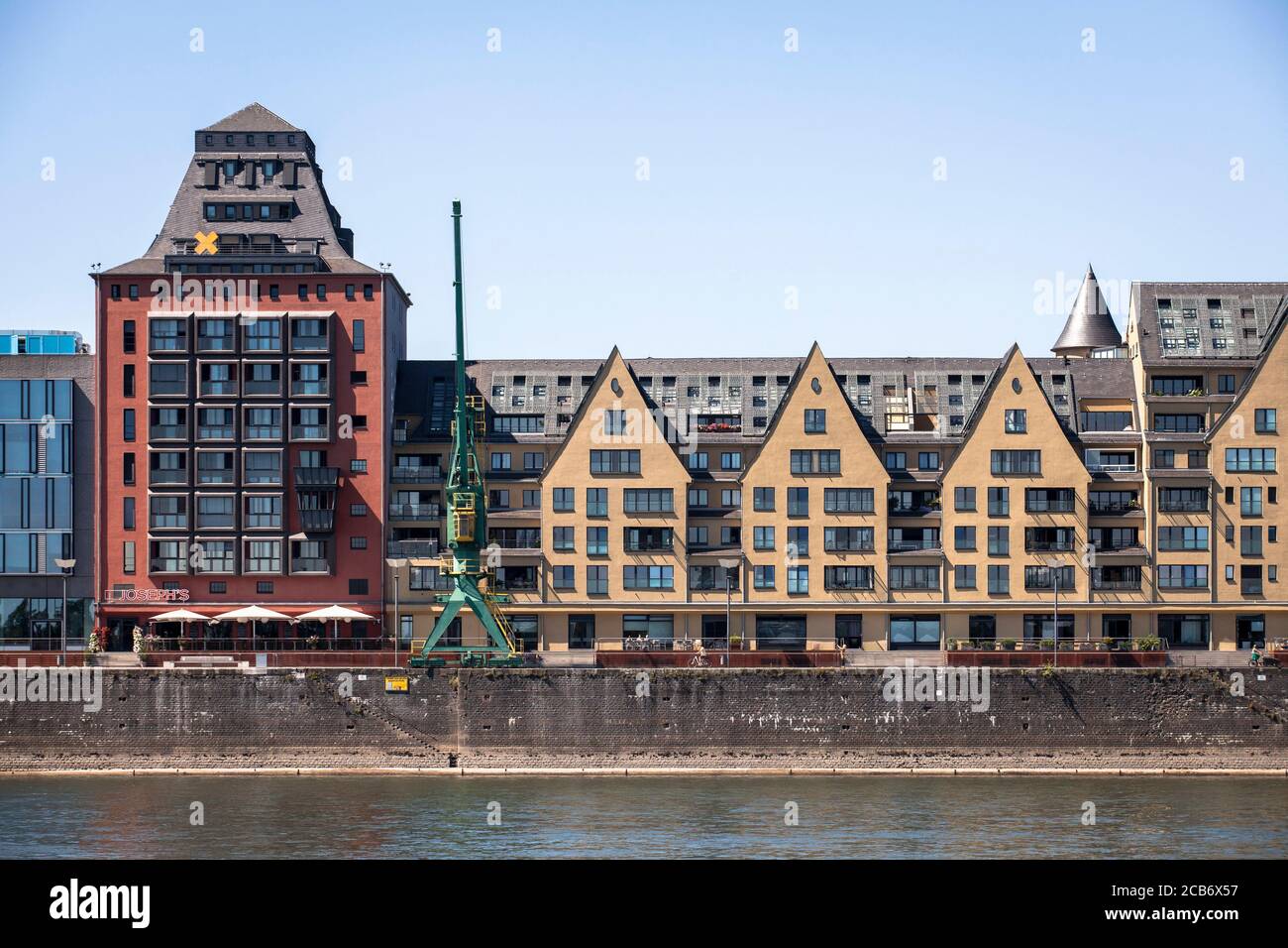 Vista sul fiume Reno fino all'edificio degli uffici Silo 23, un antico granaio e al vecchio magazzino del porto di Rheinau, Colonia, Germania. ue di Blick Foto Stock