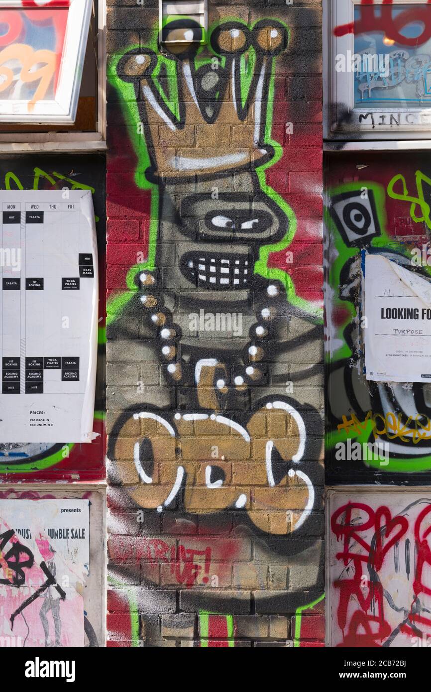Inghilterra Londra Stratford Park Hackney Wick graffiti grigio figura oro Collana con corona dorata con denti ODC Foto Stock