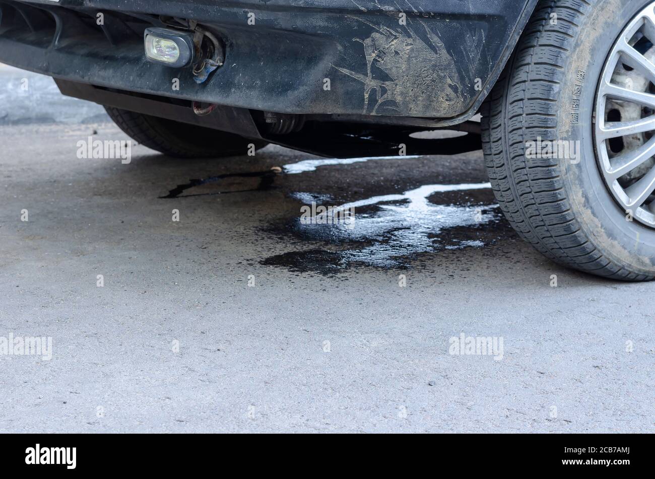Perdita di antigelo sull'asfalto a causa di un'auto danneggiata. Danni all'impianto di raffreddamento a causa di incidenti stradali. Controllo del traffico, assicurazione. Selectiv Foto Stock