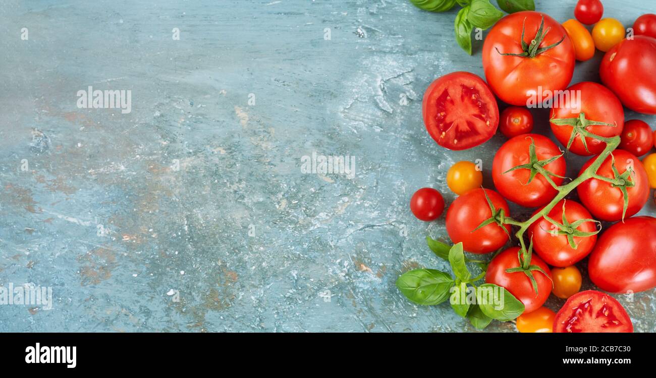 Vista dall'alto dei pomodori rossi freschi sul bordo destro di scatto su sfondo azzurro Foto Stock