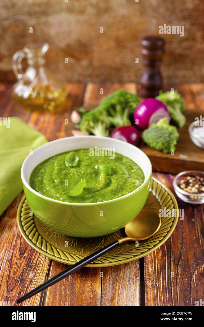 Colpo verticale di zuppa di broccoli verde vegano su rosso trendy sfondo arancione Foto Stock