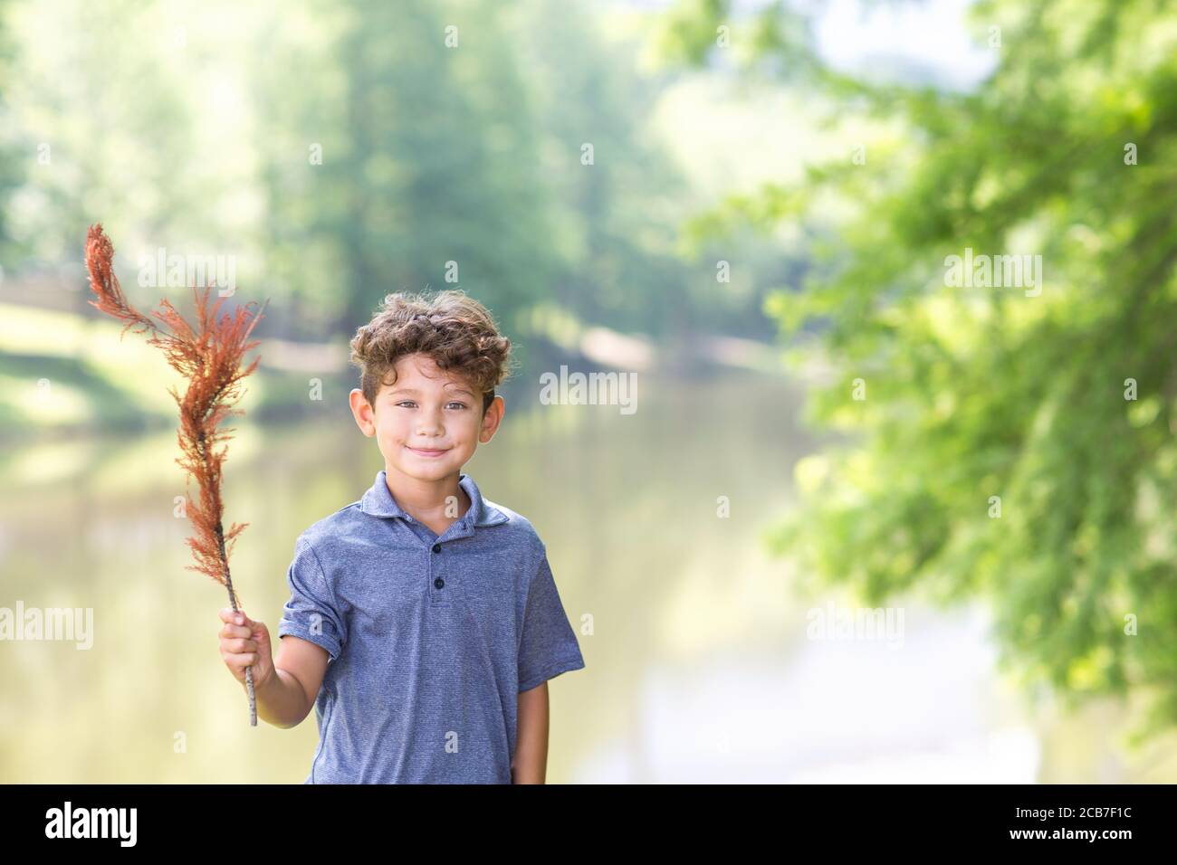 Bel ragazzo con una piuma. Foto Stock