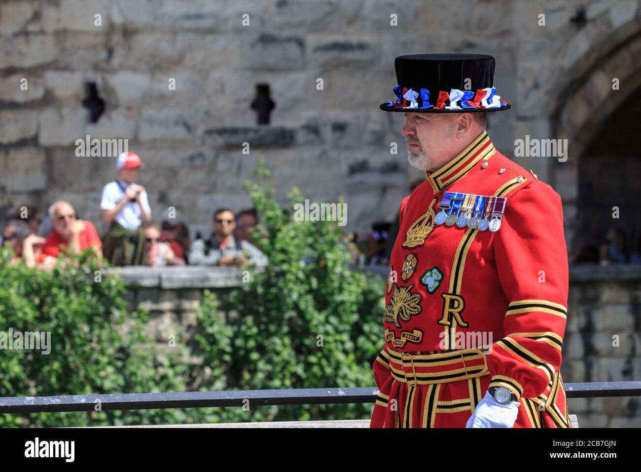 Un guerriere di yeoman, comunemente noto come Beefeater, alla Torre di Londra, in uniforme cerimoniale durante il saluto delle armi, Londra, Inghilterra Foto Stock