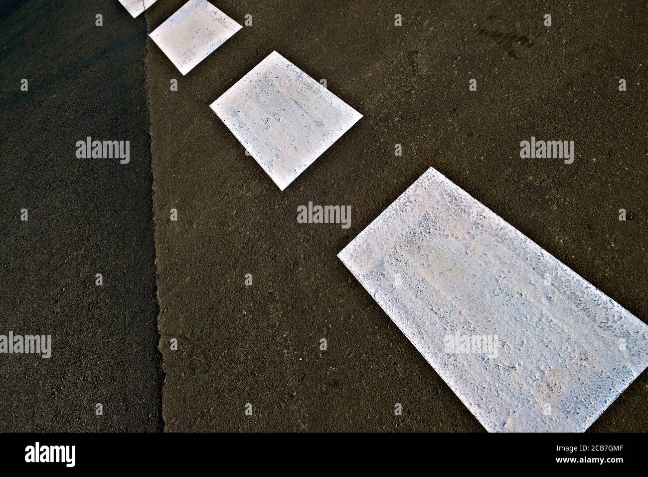 Asfalto asfalto asfaltato con linea tratteggiata verniciata bianca riflettente, prospettiva diagonale. Foto Stock