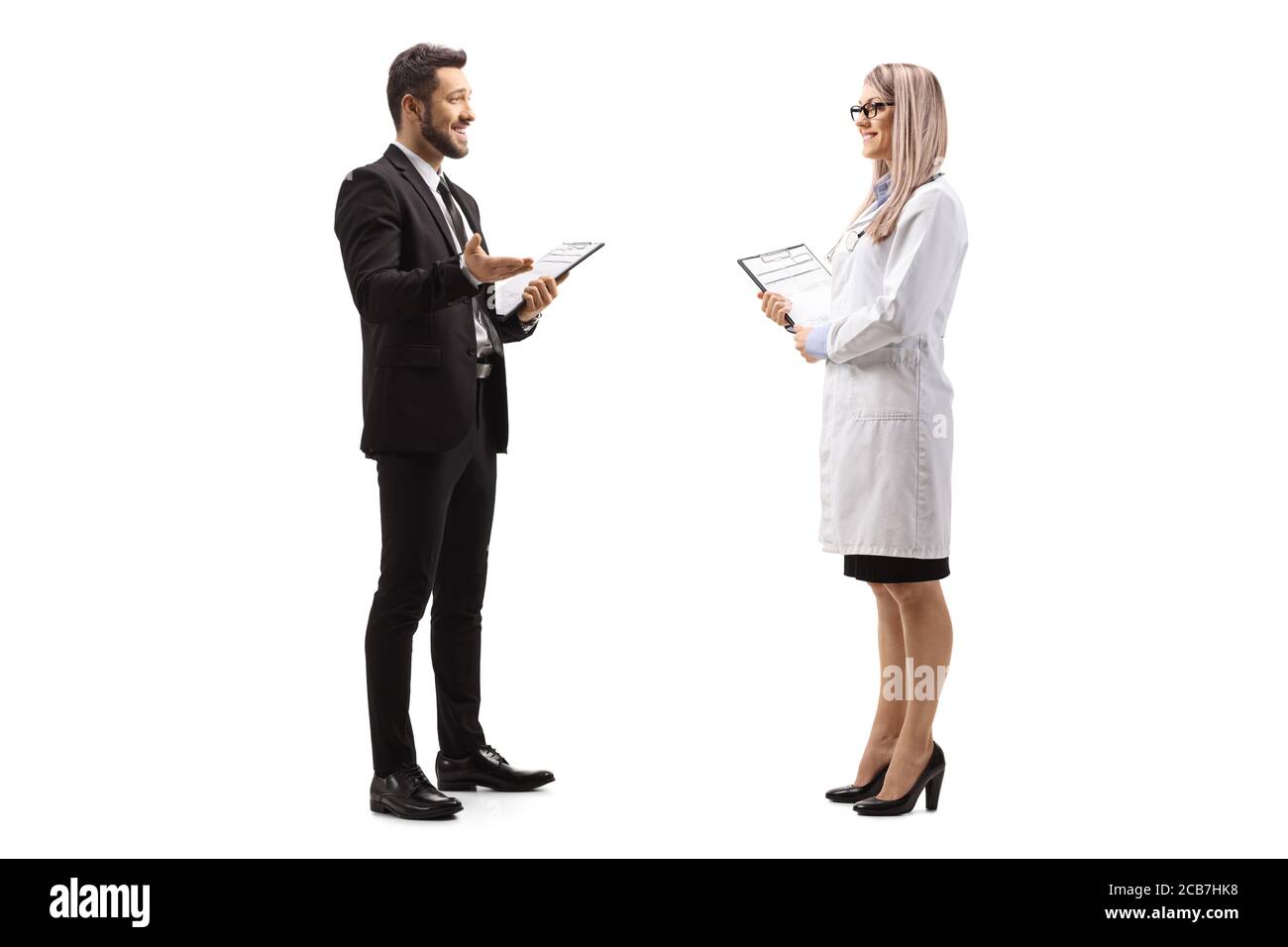 Foto di profilo a lunghezza intera di un uomo d'affari in piedi e che parla ad una dottoressa isolata su sfondo bianco Foto Stock