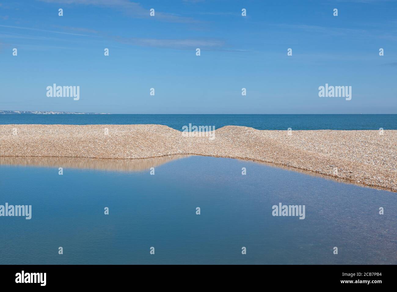 Piscina d'acqua sulla spiaggia di Dungeness, una delle più grandi spiagge di ghiaia d'Europa. Foto Stock