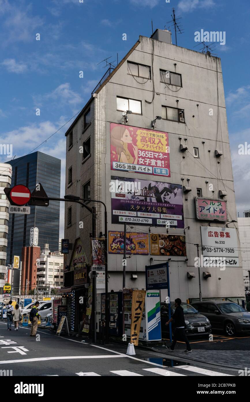 Giappone, Tokyo, Ikebukuro 06 ottobre 2019 passeggiata nel quartiere di Ikebukuro, piccolo edificio con poster pubblicitari. Foto Stock