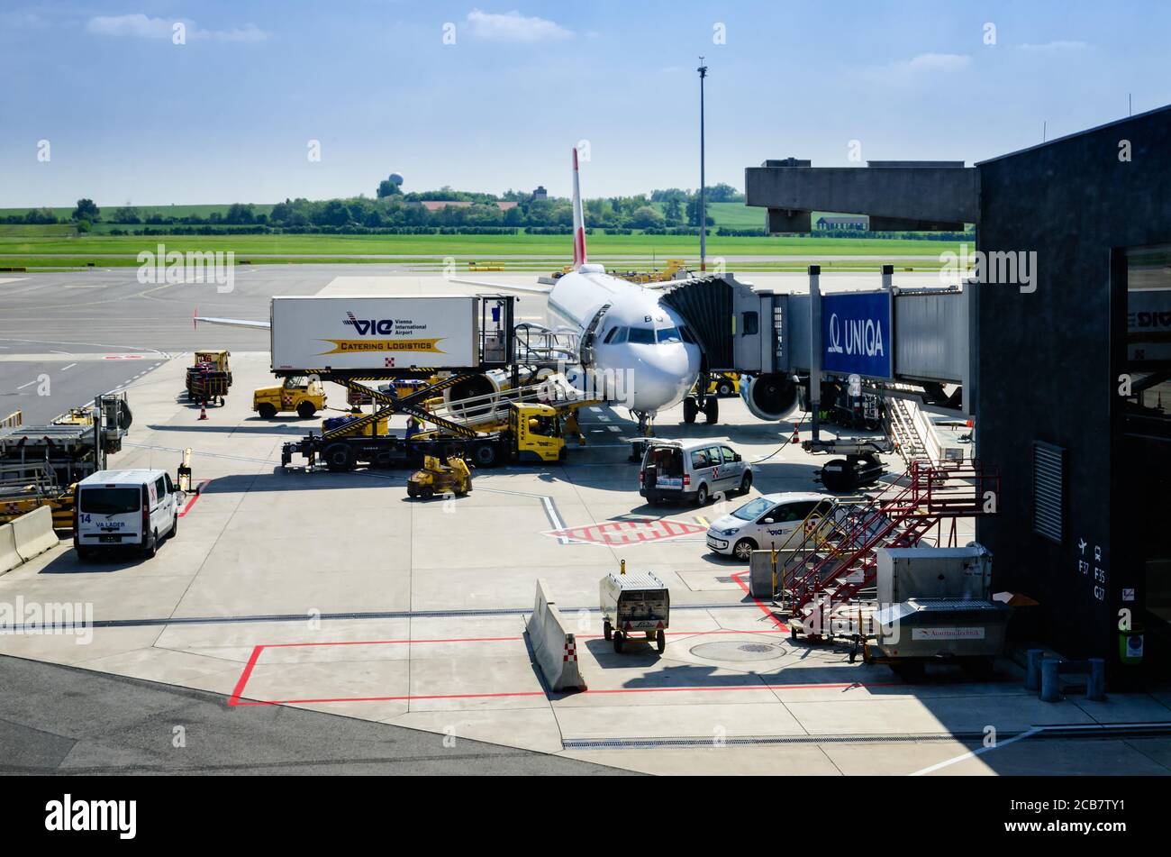 VIENNA, AUSTRIA - 17 MAGGIO 2017: Austrian Airlines Airbus all'aeroporto di Vienna Flughafen (Austria) il 22 maggio 2017. Operazione di carico con lavoratori e vehic Foto Stock