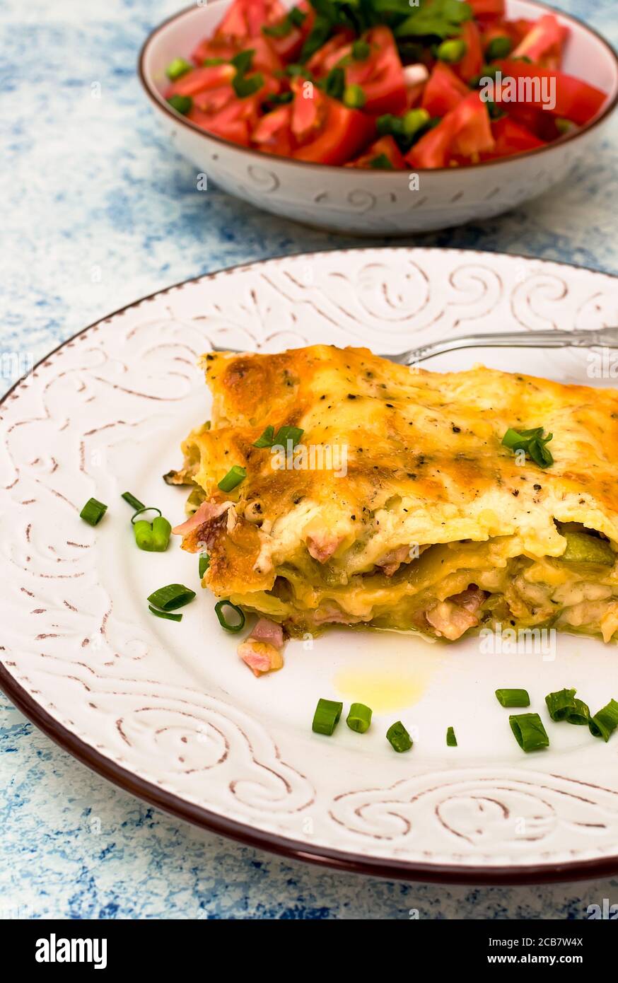 Un pezzo di lasagna appena sfornata con una crosta tostata su una piastra Foto Stock