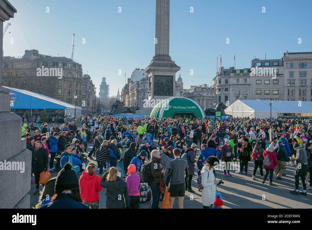 I partecipanti e i loro sostenitori hanno visto prima del loro turno di iniziare all'annuale London Winter Run Through the City a sostegno del Cancer UK. Foto Stock
