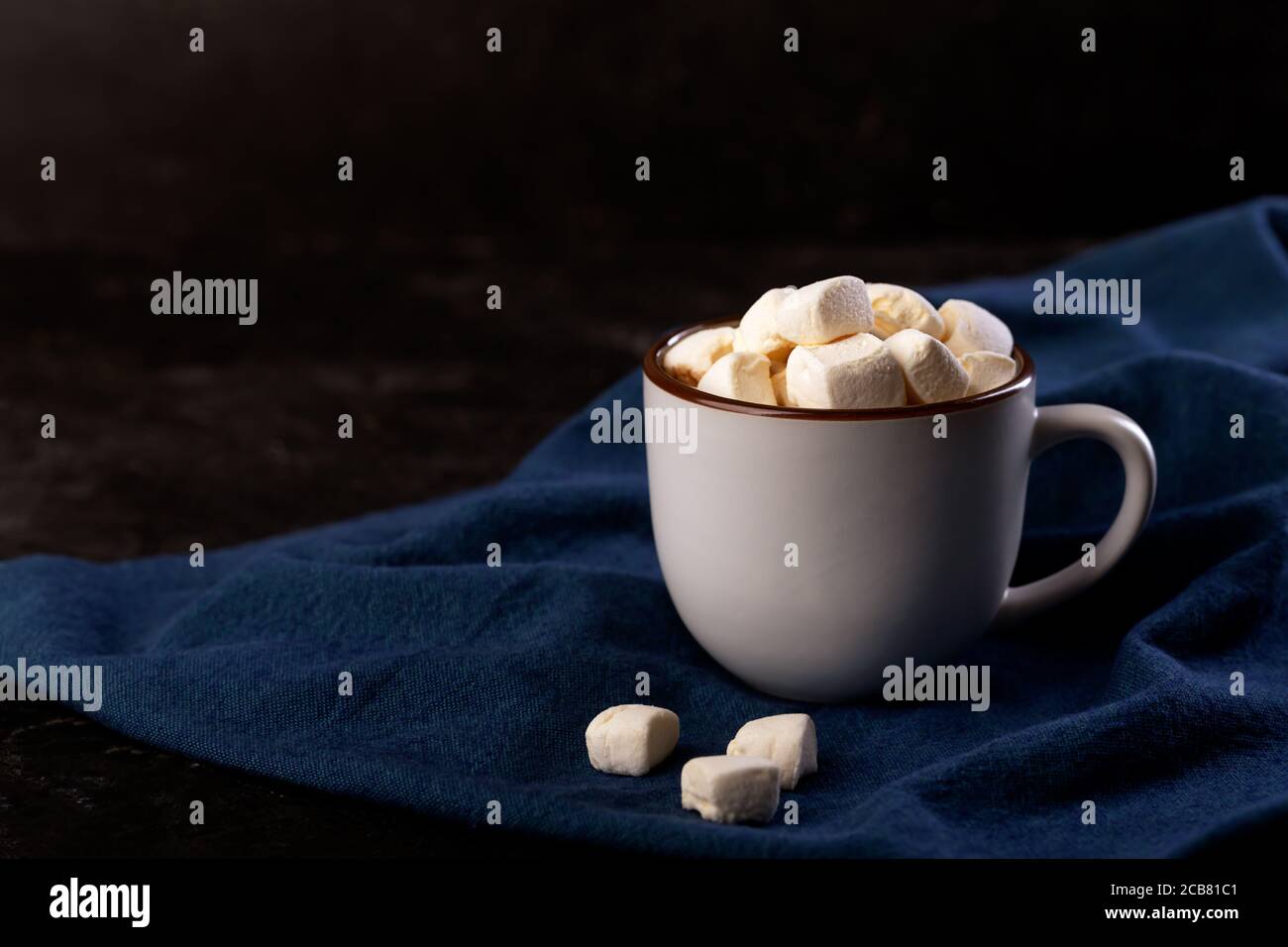 Tazza di cioccolato caldo con cannella e marshmallow su sfondo scuro Foto Stock