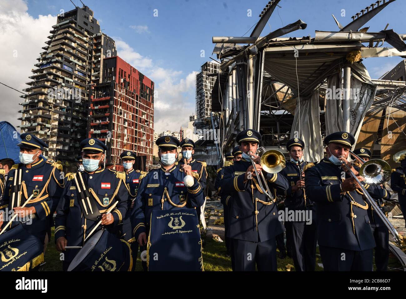 Beirut, Libano, 11 agosto 2020. Forze libanesi banda di ottone suona l'inno nazionale da di edifici distrutti, mentre le persone si riuniscono sulla strada Charles Helou, di fronte al sito dell'esplosione del porto di Beirut, in tributo alle vittime del disastro e di denunciare l'élite politica che colpiscono. Elizabeth Fitt Credit: Elizabeth Fitt/Alamy Live News Foto Stock