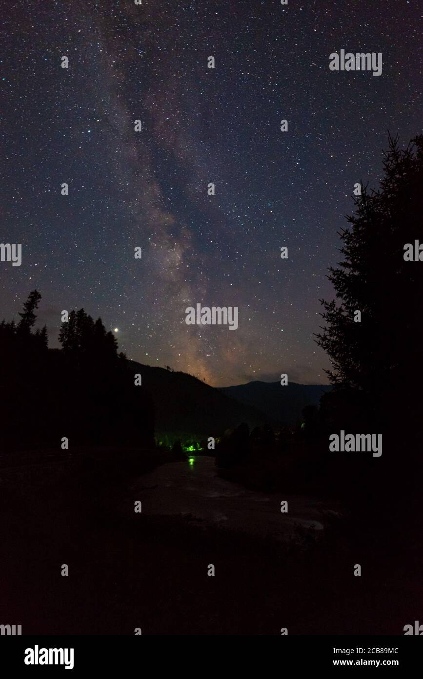 Galassia Via Lattea su acqua increspata di un fiume e. Montagne nelle Alpi Foto Stock