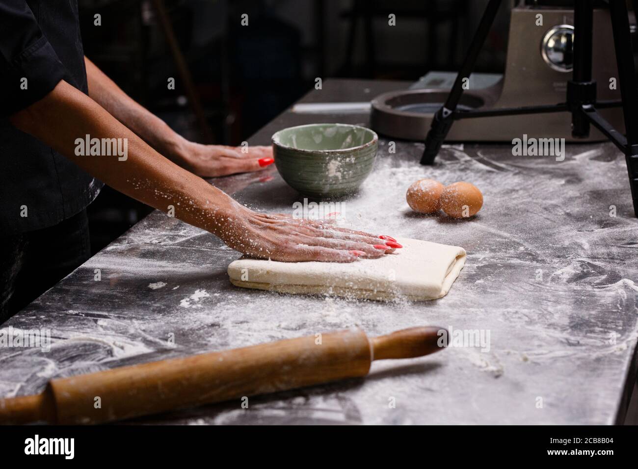 Lo chef prepara dolci in una cucina professionale. Sfondo scuro. Foto Stock