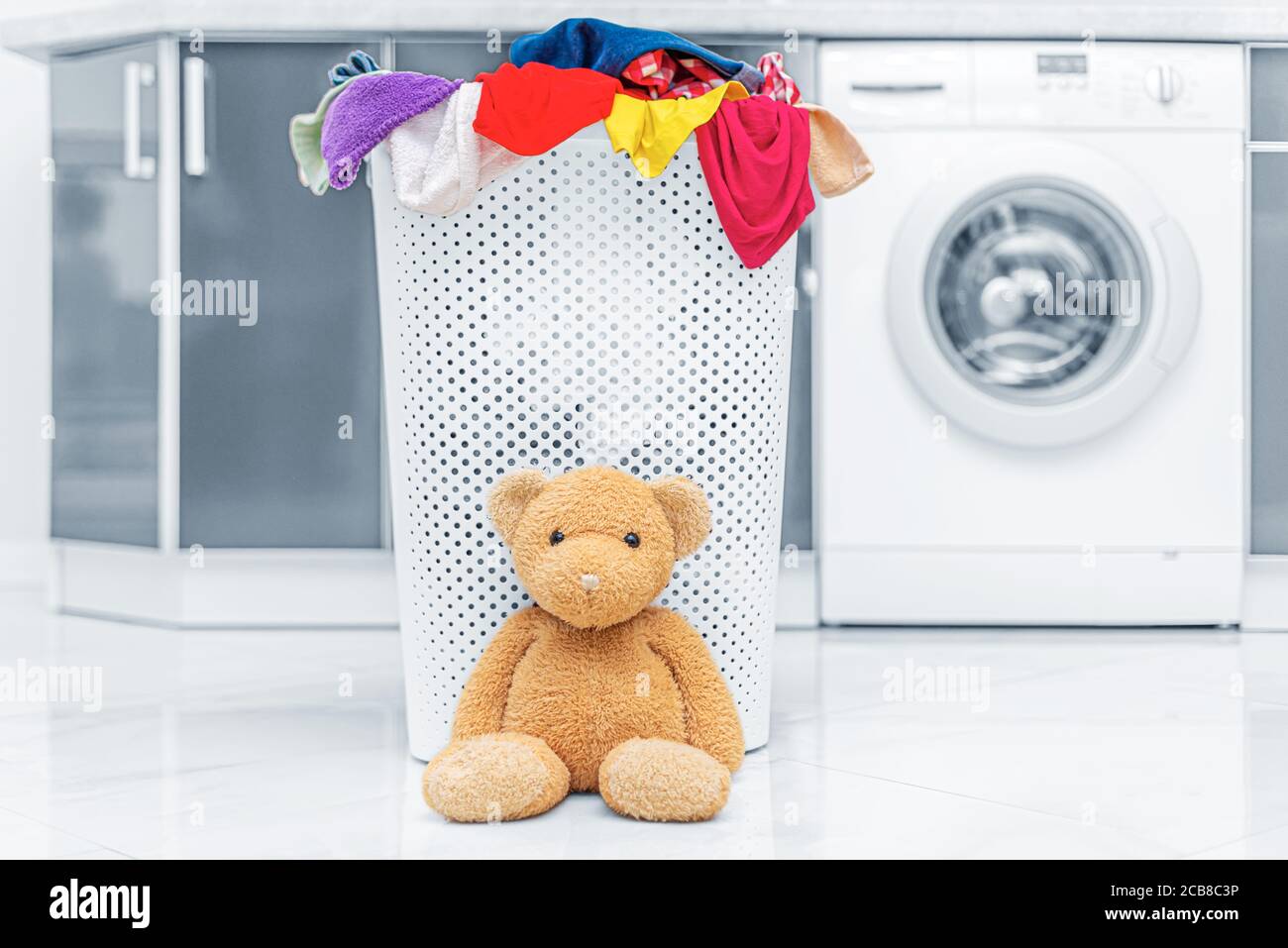 Cesto di biancheria da letto e da bagno sullo sfondo di una macchina di lavaggio. Foto Stock