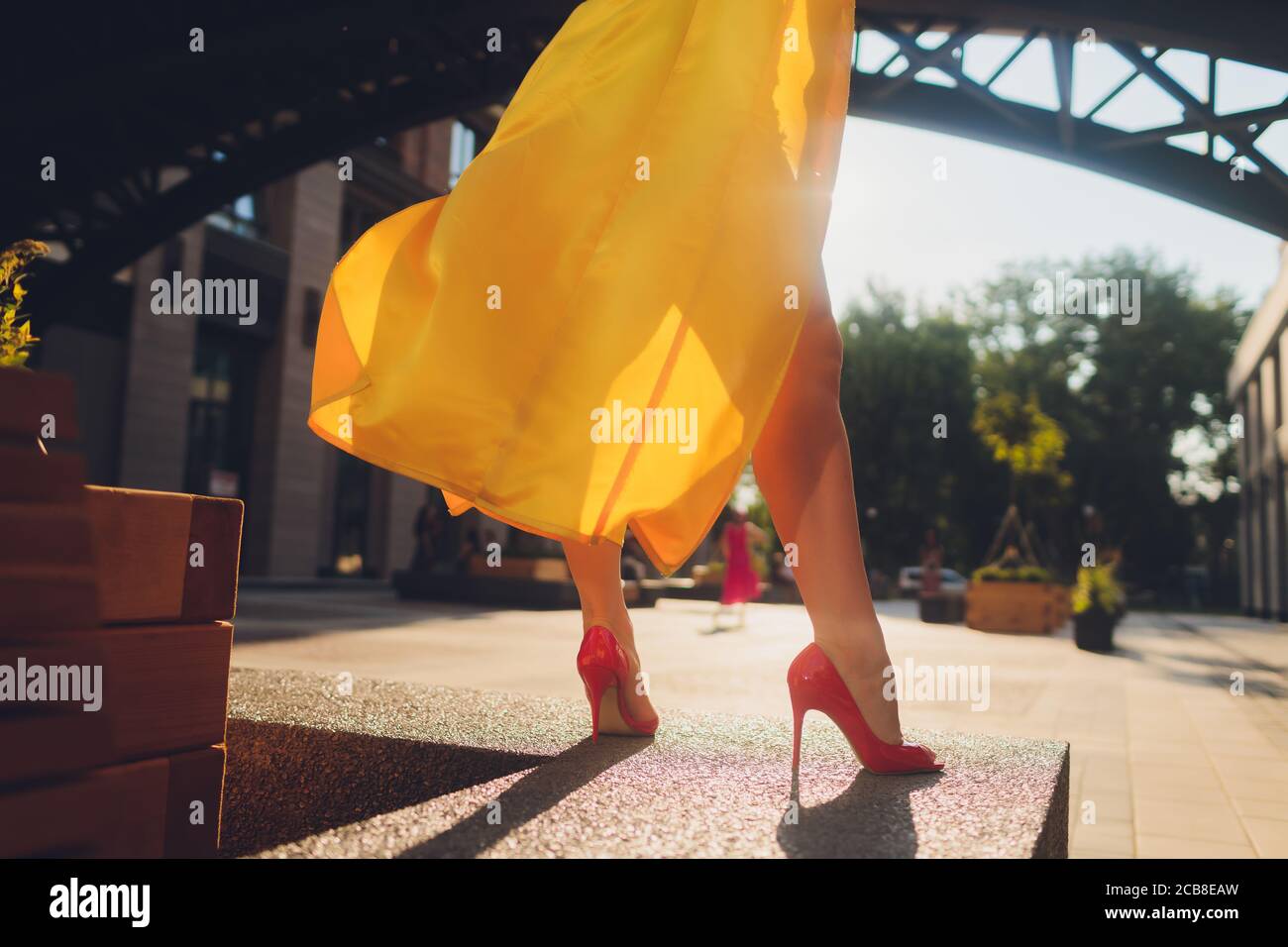 Visualizzazione delle tendenze della moda. Attraente donna dai capelli scuri che postura in giallo chiaro morbido mantello. Foto Stock