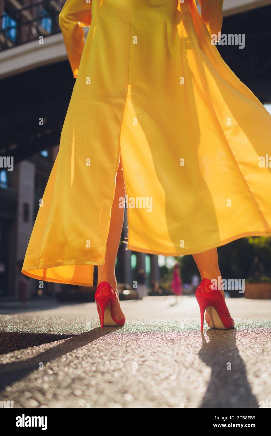 Visualizzazione delle tendenze della moda. Attraente donna dai capelli scuri che postura in giallo chiaro morbido mantello. Foto Stock