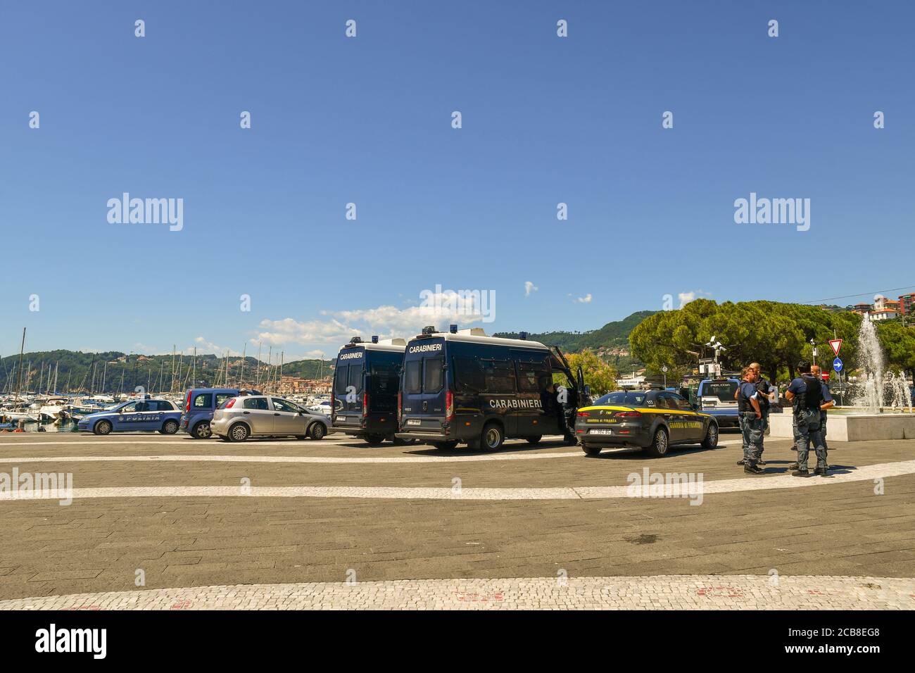 Veicoli di polizia italiani e un gruppo di poliziotti in attesa dell'arrivo del politico Matteo Salvini per un rally nella città marina di Lerici, Italia Foto Stock