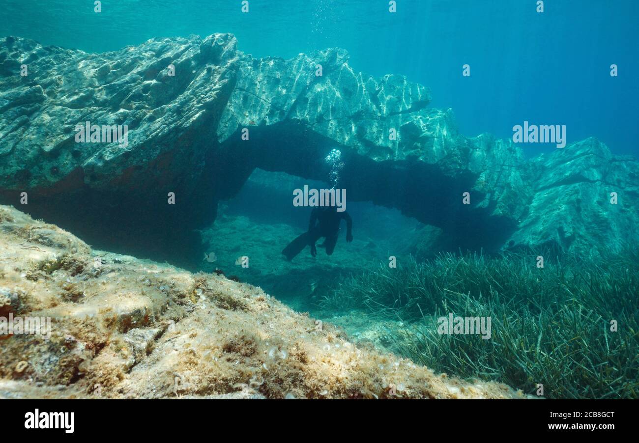 Formazione rocciosa, arco naturale sottomarino con un uomo freewiving nel Mar Mediterraneo, Catalogna, Cap de Creus, Costa Brava, Spagna Foto Stock