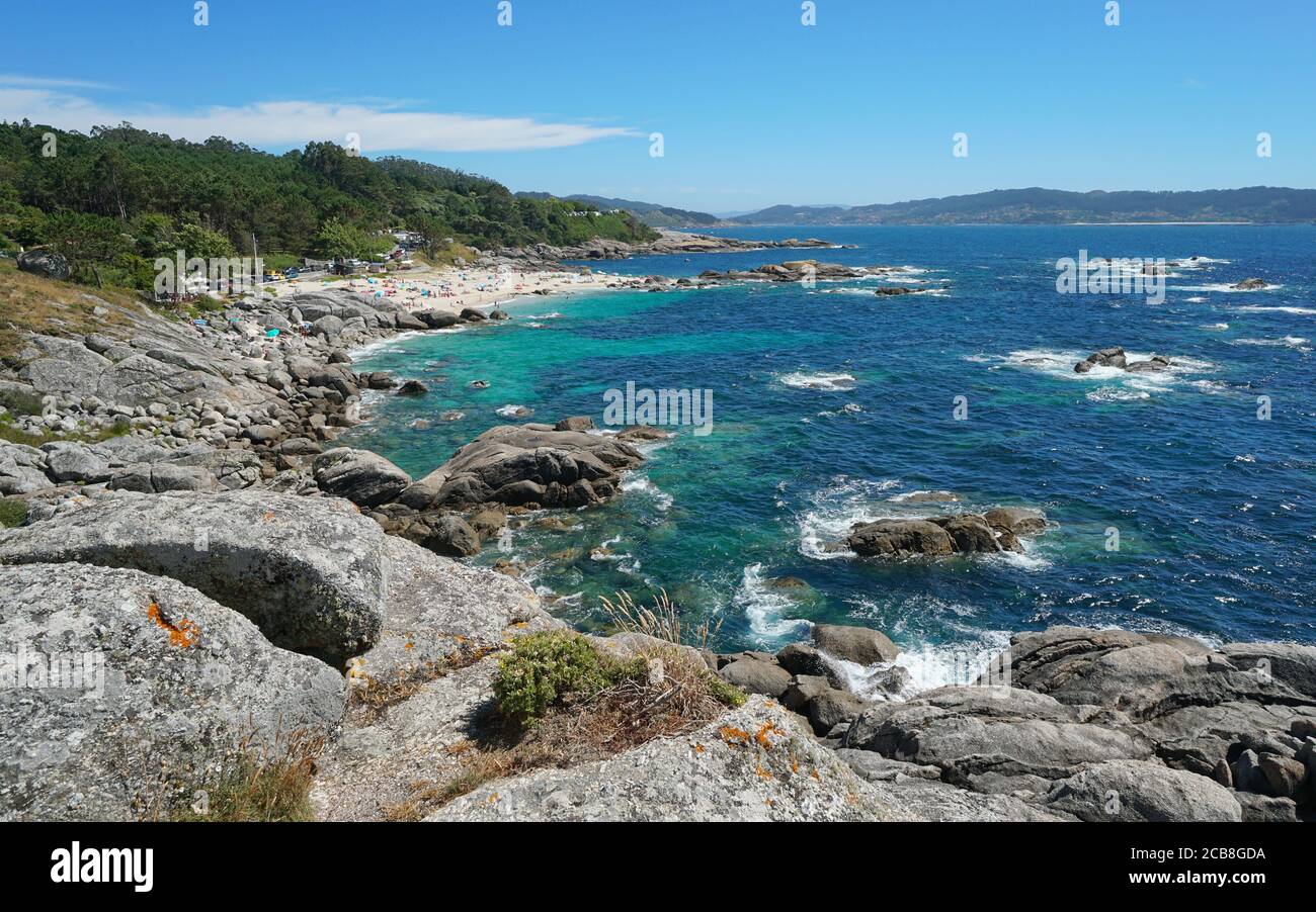 Spagna, Galizia, costa rocciosa con spiaggia in estate, oceano Atlantico, Bueu, provincia di Pontevedra, Praia de Lagos Foto Stock