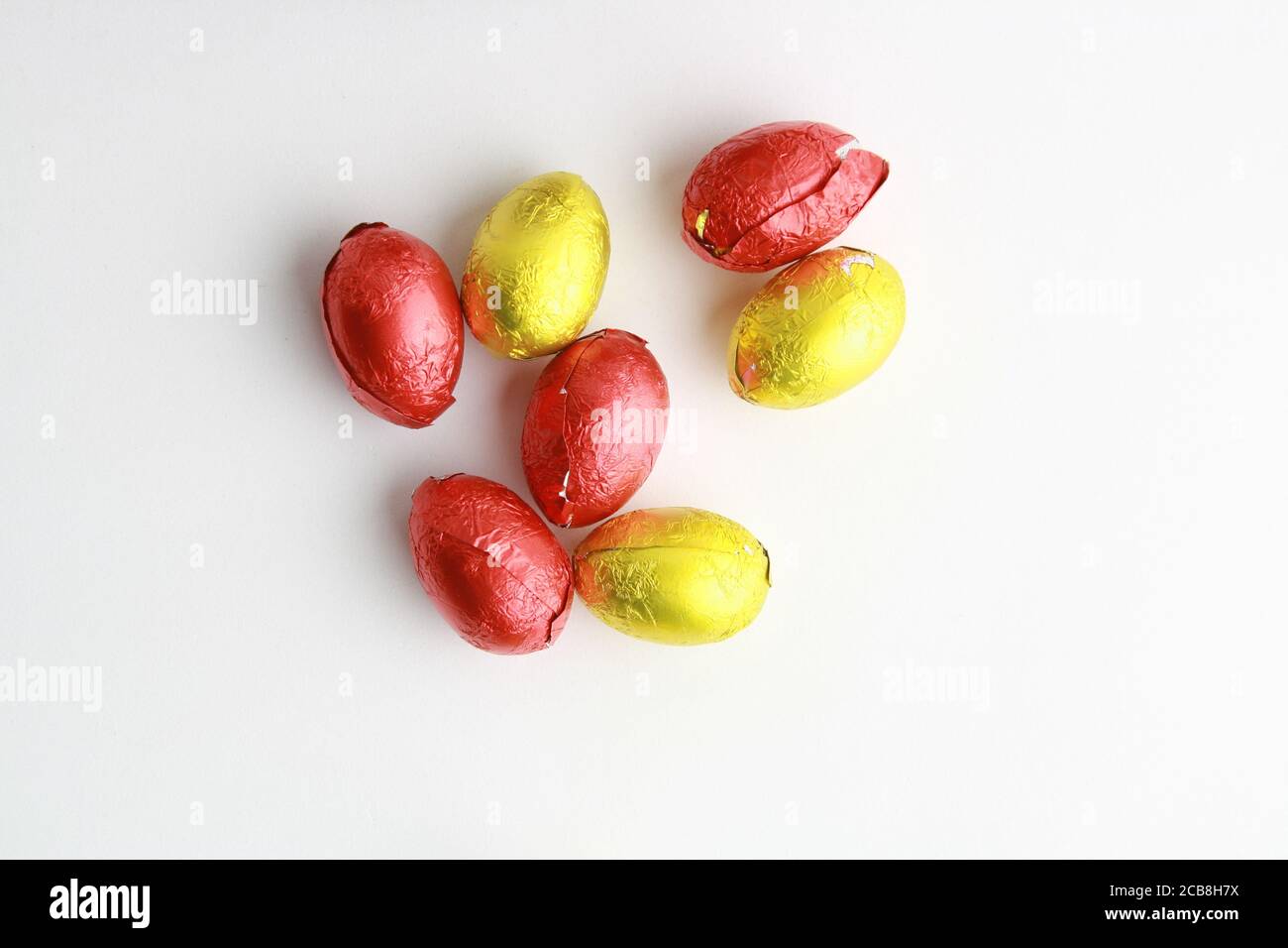 Closeup di caramelle al cioccolato di Pasqua uovo avvolto in giallo e. carta  rossa Foto stock - Alamy