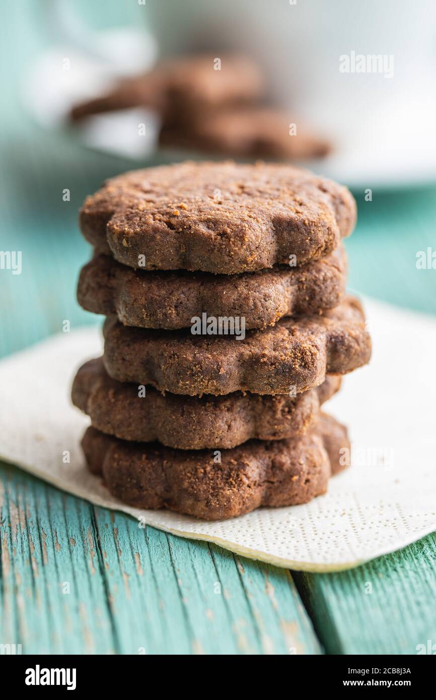 Biscotti dolci. Croccanti biscotti al cioccolato forma fiore su tavola di legno verde. Foto Stock