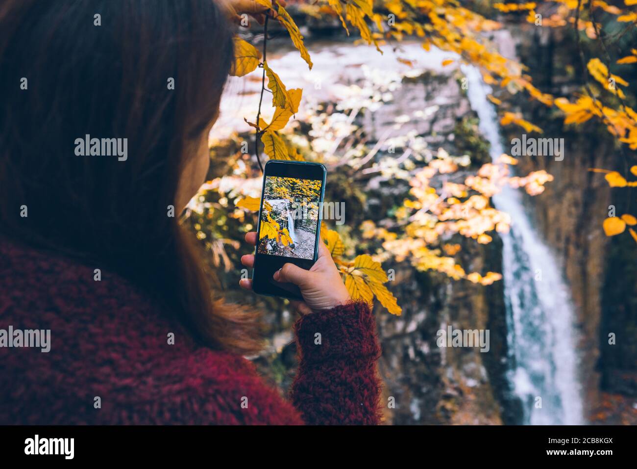 La donna sta immagine di autunno cascata sul telefono Foto Stock