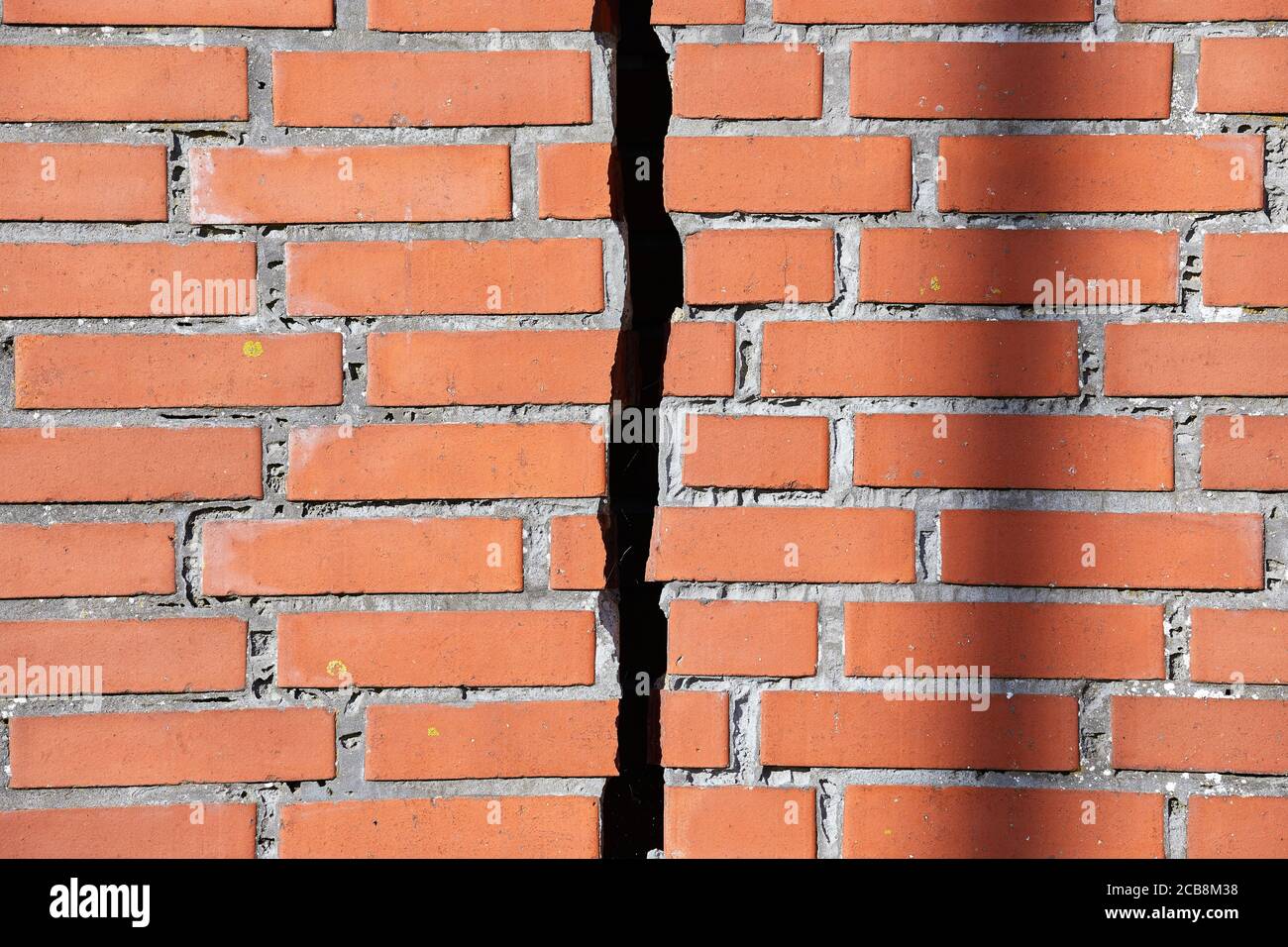 Muro di mattoni rossi con una crepa Foto Stock