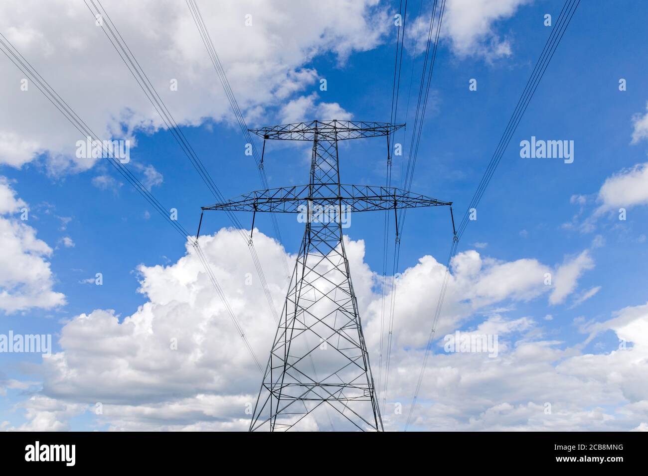 Una grande pilone di elettricità di metallo o torre di trasmissione contro un cielo blu con nuvole Foto Stock