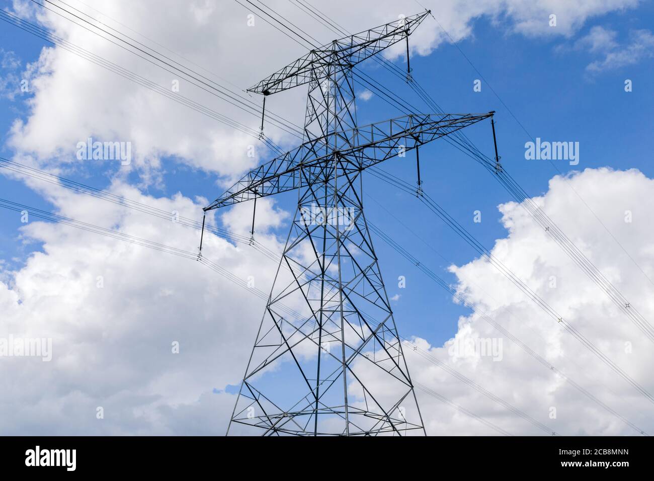 Una grande pilone di elettricità di metallo o torre di trasmissione contro un cielo blu con nuvole Foto Stock