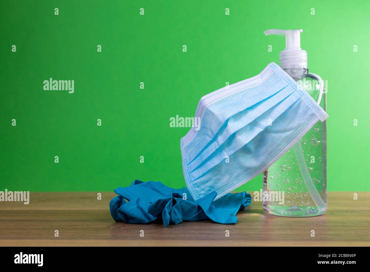 Gel disinfettante antibatterico, maschera e guanti per misure preventive di coronavirus, covid-19 con fondo verde Foto Stock
