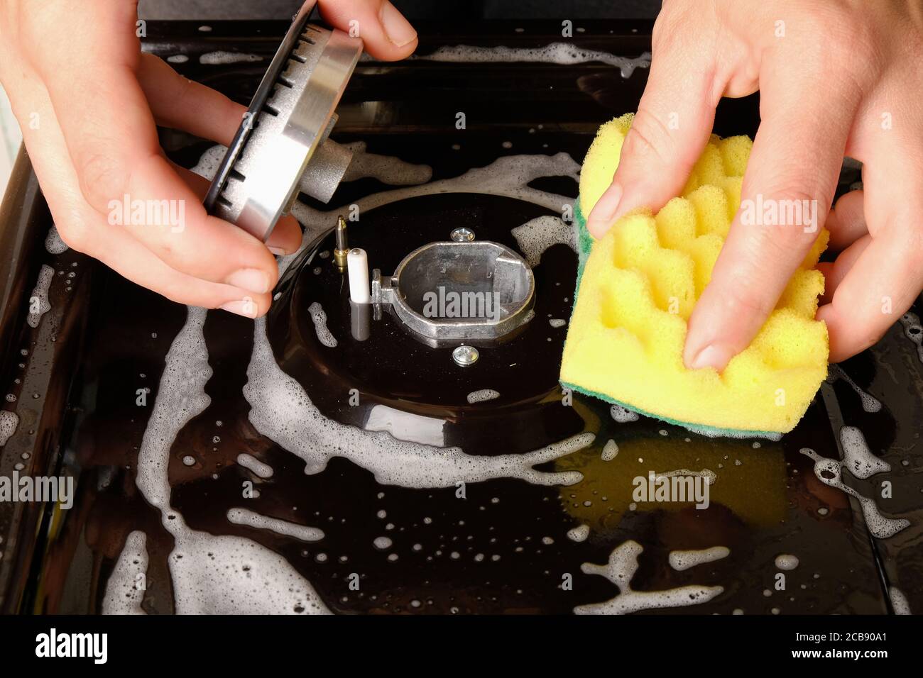 stufa a gas, pulizia della superficie, lavaggio della stufa a gas con un panno in cucina. Foto Stock