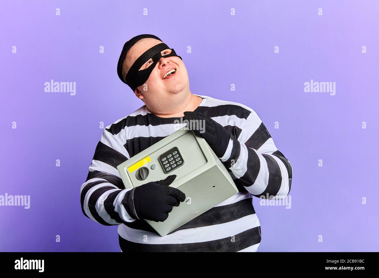 il sogno del ladro diventa realtà. primo piano ritratto. sfondo blu isolato. studio shot. felicità. Foto Stock