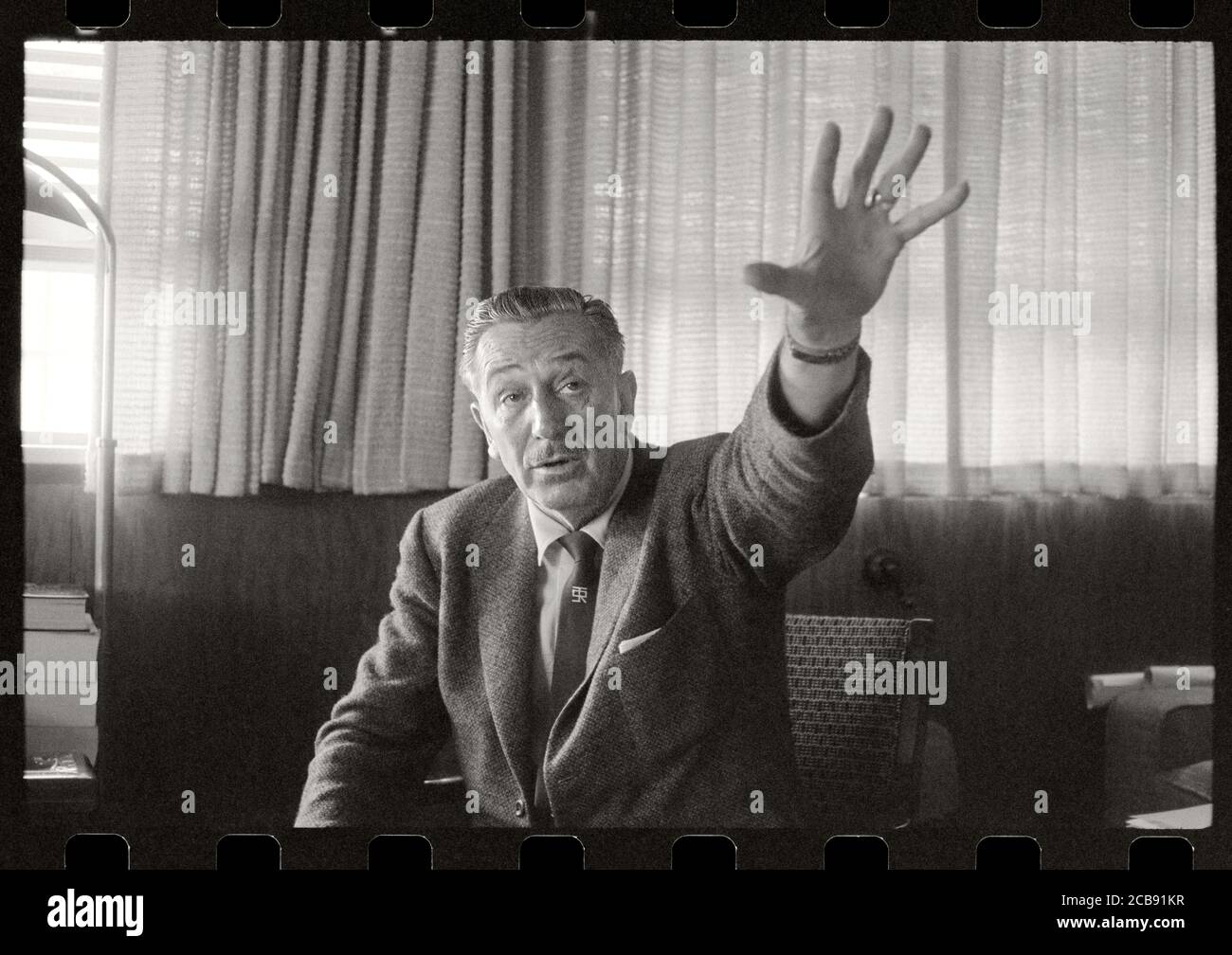 Il pioniere del cinema Walt Disney con la mano descrive la sua visione per Disneyland. Il suo cravatta ha mostrato il logo per la sua casa di vacanza, Smoke Tree Ranch. Immagine da negativo 35 mm. Foto Stock