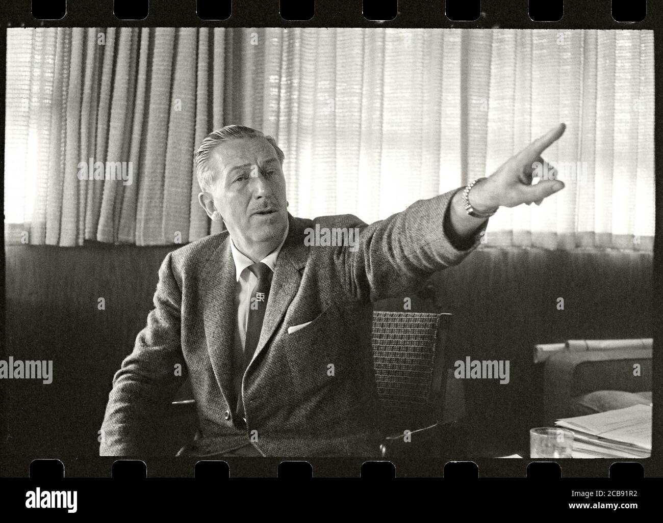 Il pioniere del cinema Walt Disney punta il dito mentre descrive la sua visione per Disneyland. Il suo cravatta ha mostrato il logo per la sua casa di vacanza, Smoke Tree Ranch. Immagine da negativo 35 mm. Foto Stock