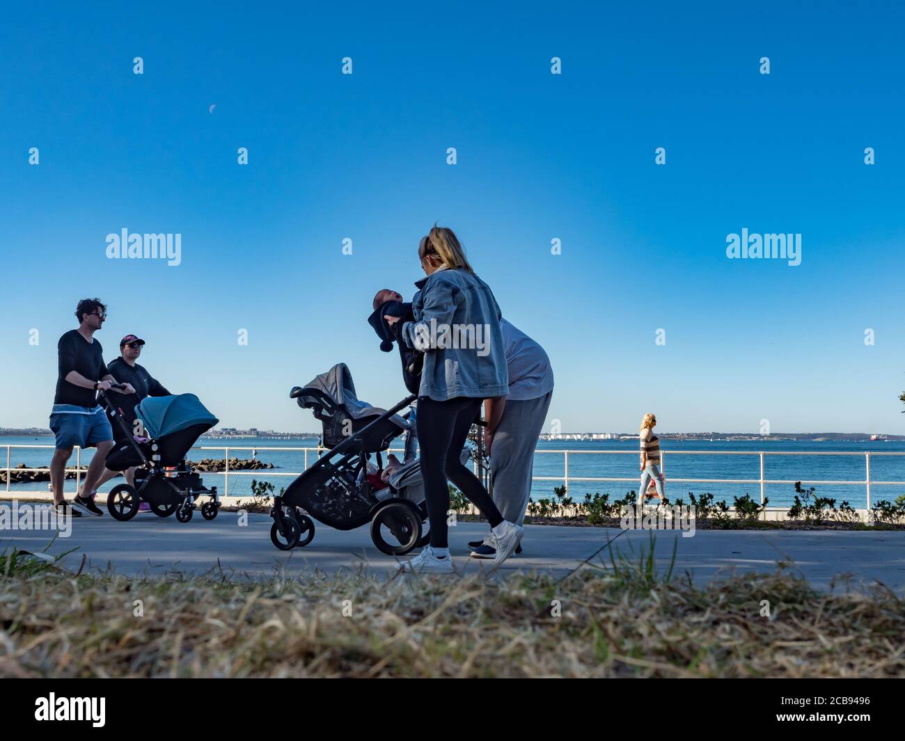 Famiglie Passeggiate sul sentiero di Ramsgate Beach in un inverno soleggiato pomeriggio Foto Stock