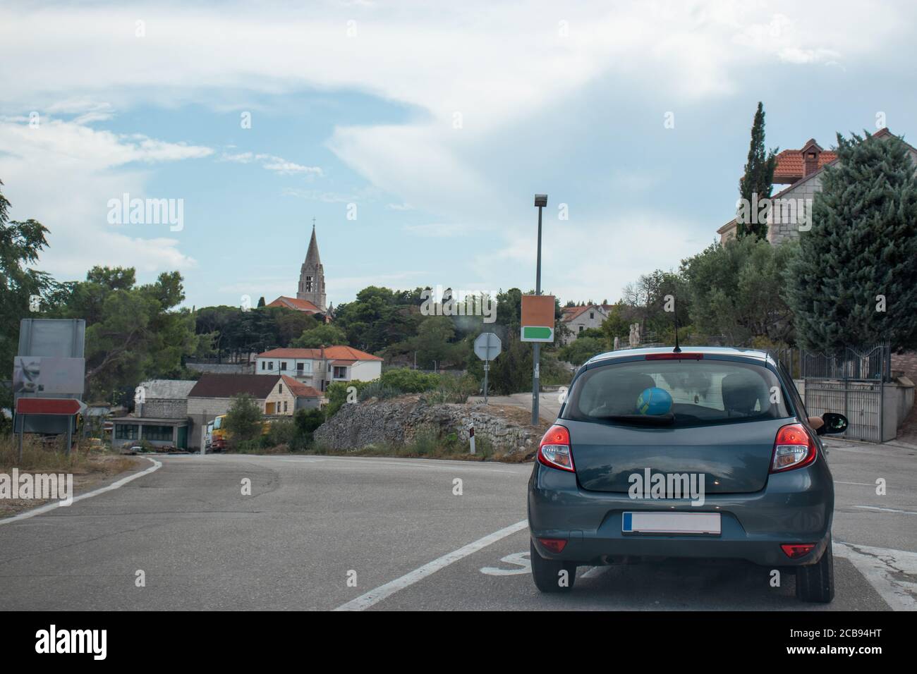 Piccolo hatchback grigio che sorge su un incrocio nella città di Selca, piccolo vilaggio sull'isola di Brac Foto Stock
