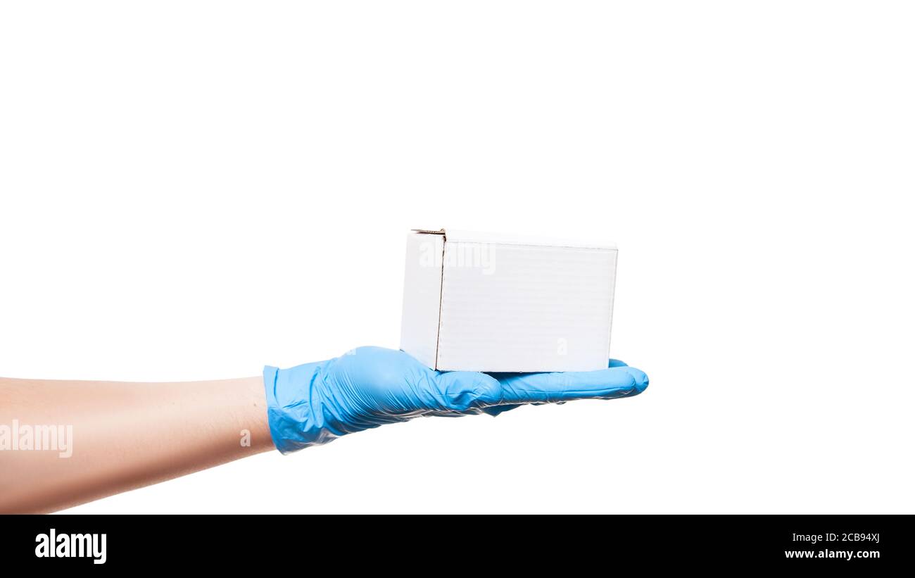 Consegna mano uomo in guanto di lattice sterile blu dimostrare etichetta bianca scatola di cartone sul palmo, consegna sicura durante la quarantena rimanere a casa, isolato su wh Foto Stock