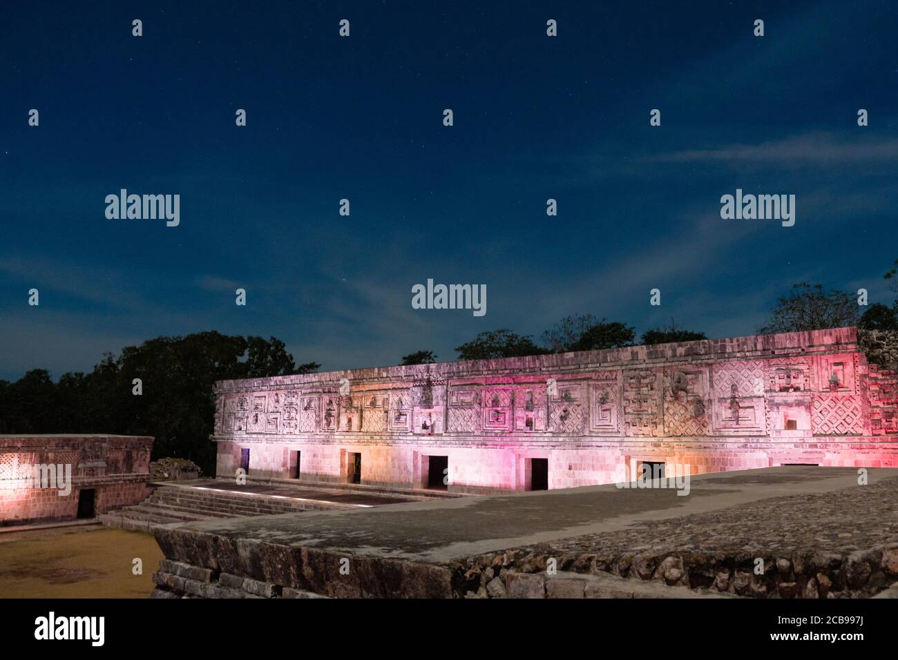 L'edificio ovest del Nunnery Quadrangle è illuminato da luci colorate nelle rovine maya pre-ispaniche di Uxmal, Messico. Foto Stock