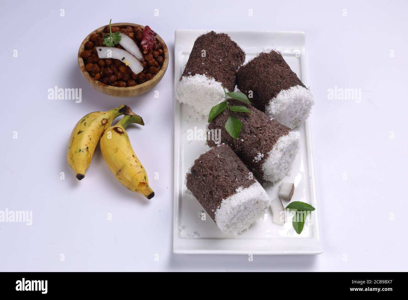 Ragi Puttu o Millet Puttu, colazione kerala fatta in casa Usando il miglio di dito e cocco essiccato, cibo indiano messo su un stoviglie bianche con ka Foto Stock