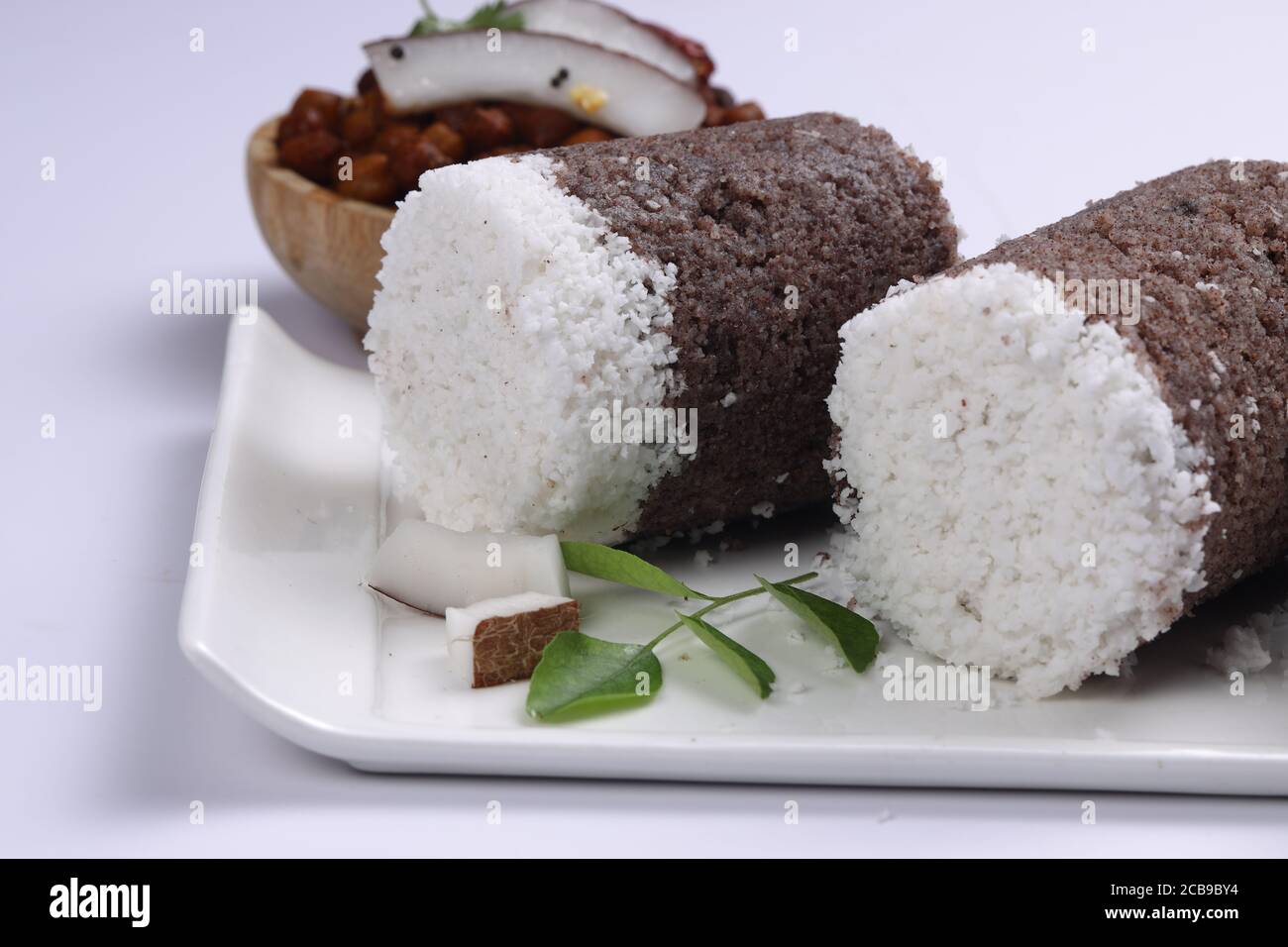 Ragi Puttu o Millet Puttu, colazione kerala fatta in casa Usando il miglio di dito e cocco essiccato, cibo indiano messo su un stoviglie bianche con ka Foto Stock