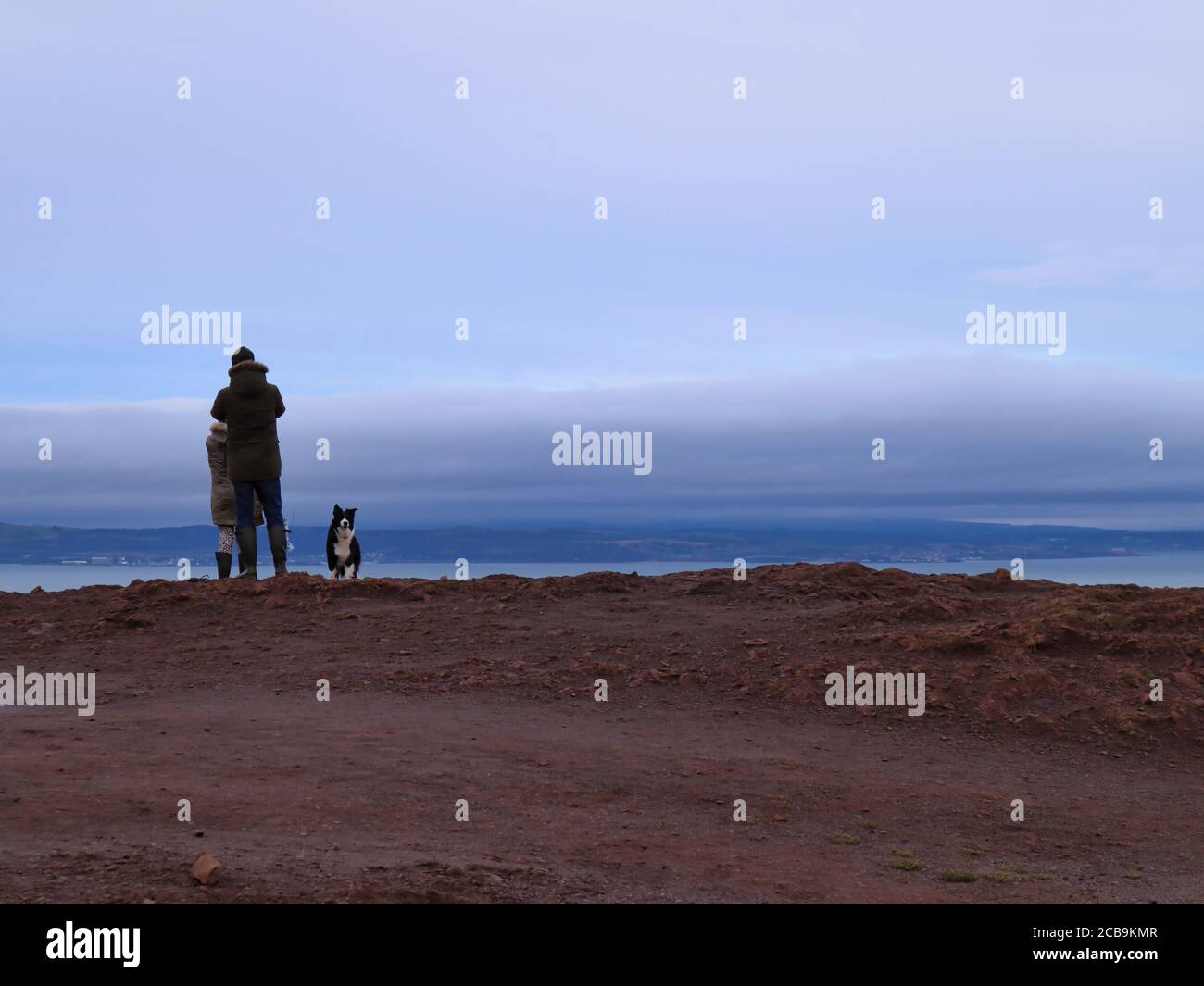 Moody Clouds; Dog in the Foreground; Edinburgh in the background; Arthur's Seat Landscape; Border Collie on the Arthur's Seat Foto Stock