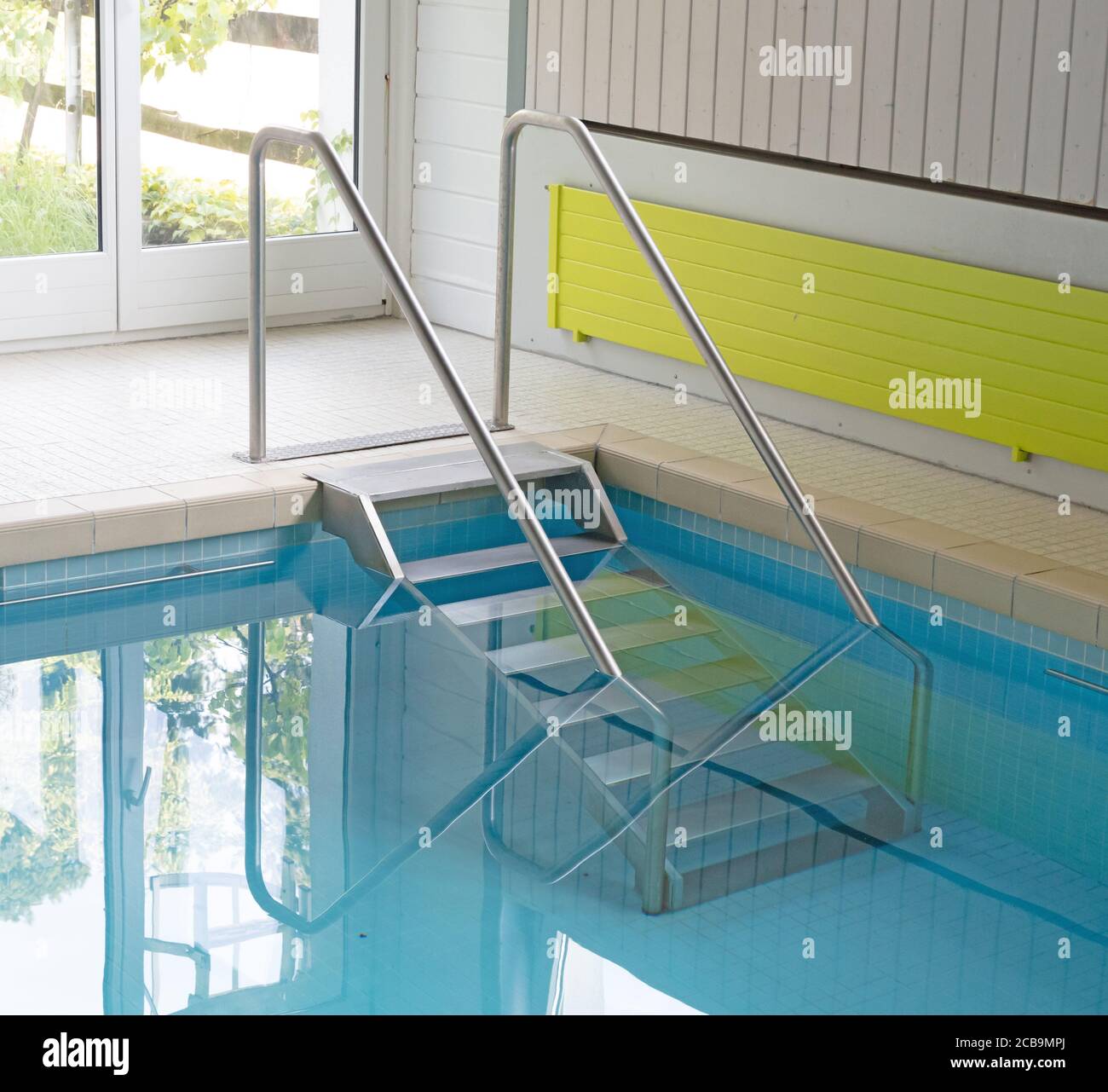 Scale metalliche in una piscina interna Foto Stock