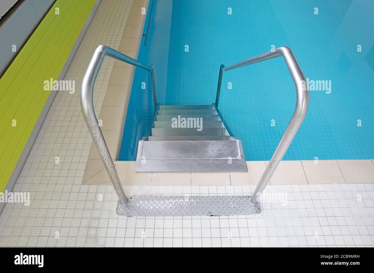 Scale metalliche in una piscina interna Foto Stock