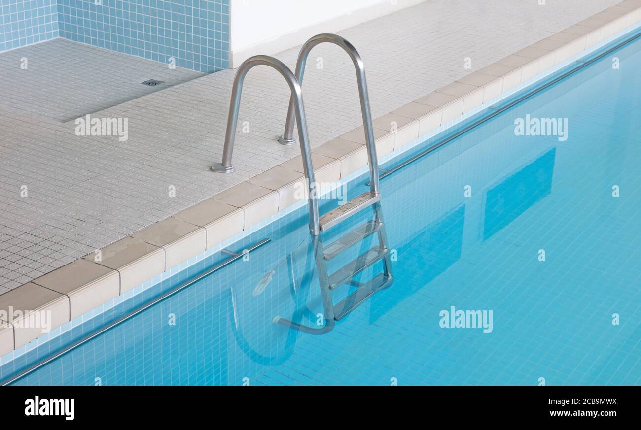 Scale metalliche in una piscina interna Foto Stock